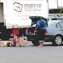 Manna food center, loading a box of food into a car